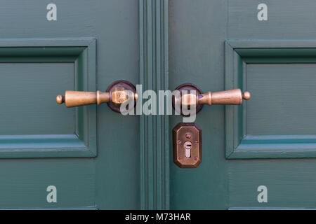 Goldene Türgriffe auf grünen Holztüren. Alte Türgriff Stockfoto