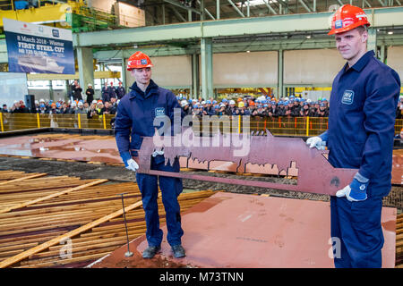 13. Februar 2018, Deutschland, Wismar: Die Lehrlinge Martin Haecker (L-R) und Erik Merck Holding a Stahl auf der Maschine mit dem Umriss der Zukunft global Cruise Ship. Der offizielle Start der rund eine Milliarde Euro teurer, 340 Meter länger und 20 Decks höher Schiff gefeiert. Foto: Jens Büttner/dpa Stockfoto