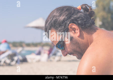 Junge Bartgeier kaukasischen Mann mit Sonnenbrille genießen den Sommer am Strand Stockfoto
