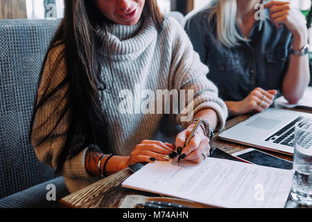 Geschäftsfrau einen Vertrag in einem Cafe an einem Holztisch Stockfoto