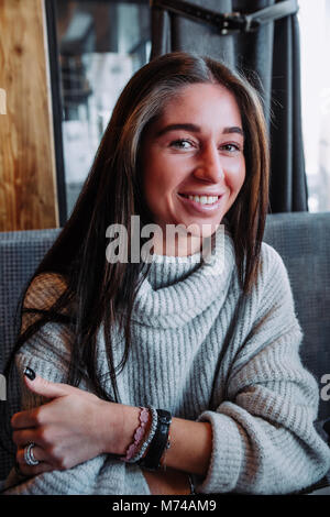 Schönen Lächeln, brünett in einem grauen pullover an Kamera lächeln Stockfoto