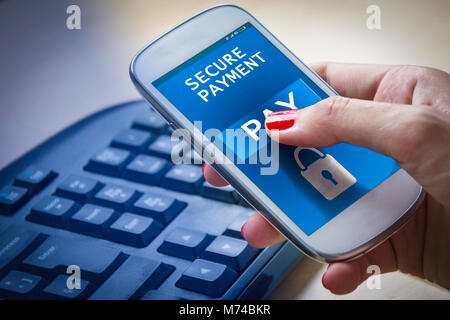 Weibliche Hände mit einem Smartphone mit gesicherter Zahlung auf dem Bildschirm. Stockfoto