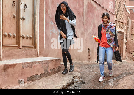 Abyaneh, Iran - April 26, 2017: Zwei junge Frauen in hijabs sind entlang einer engen Straße in der traditionellen Dorf in den Bergen und Lachen. Stockfoto
