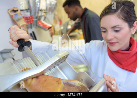 Frau Schweinefleisch Metzgerei serviert Würstchen an Kunden Stockfoto
