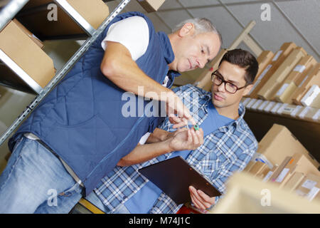 Mitarbeiter und Kollege stocks Controlling im Lager Stockfoto