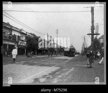 Dieses Bild zeigt Straßenszenen in Tokio, Japan, und zeigt das urbane Leben des frühen 20. Jahrhunderts. Das Foto bietet einen Einblick in die geschäftigen Straßen und architektonischen Besonderheiten der Stadt während dieser Zeit. Stockfoto
