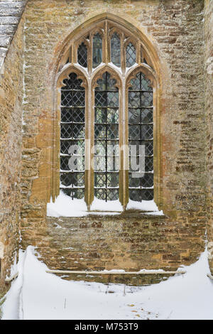 Gewölbte verbleite Fenster in St. Kenelm's Kirche im Winter Schnee. Minster Lovell, Oxfordshire, England Stockfoto