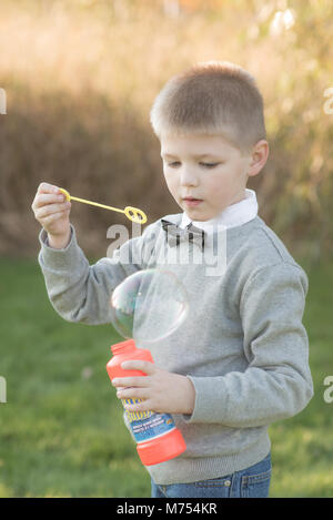 Sieben Jahre alten Jungen spielen im Freien im Herbst Stockfoto