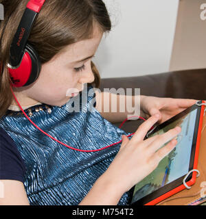 Quadrat Portrait eines jungen Mädchens spielen auf einem Laptop. Stockfoto