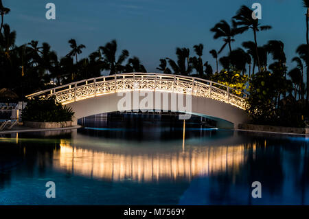 Lange Belichtung einer beleuchteten Fuß Brücke über einen Pool als dawn Breaks. Stockfoto