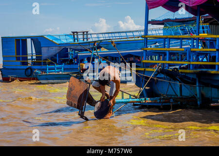 TONLE SAP, Kambodscha - 8. APRIL: Guy Instandsetzung der Motor des Bootes in den Tonle Sap schwimmendes Dorf. April 2017 Stockfoto