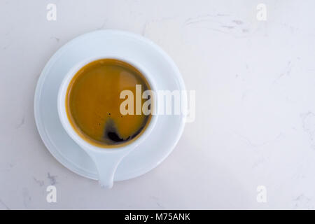 Americano Kaffee Tasse und Teller auf dem weißen Marmor tisch am Morgen Zeit. nach oben anzeigen und kopieren. Stockfoto