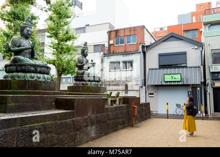 Tokyo, Japan - 20. Februar 2018: Die japanische Frau mit ein bisschen Glück vor Buddha Statuen, bevor Sie am Morgen zur Arbeit zu beten. Eine einfache Li Stockfoto