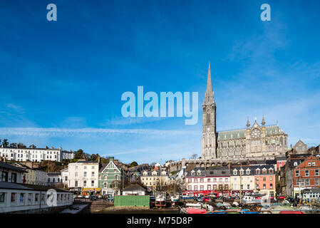 Cobh, Irland - 9 November, 2017: Hafen von Cobh mit St. Colman Kathedrale im Hintergrund ein sonniger Morgen mit blauem Himmel. Cobh ist eine malerische Iris Stockfoto