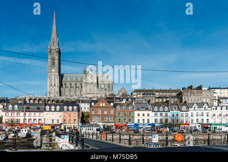 Cobh, Irland - 9 November, 2017: Hafen von Cobh mit St. Colman Kathedrale im Hintergrund ein sonniger Morgen mit blauem Himmel. Cobh ist eine malerische Iris Stockfoto