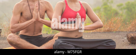 Mitte der Schuß Nahaufnahme einer Frau und Mann sitzen und meditieren mit Hände im Gebet. Stockfoto