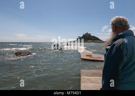 St. Michaels Mount, England, Juli 21, 2010: Ein älterer Mann auf einem Boot, Tourist, St Michaels Mount in Cornwall wartet. Stockfoto