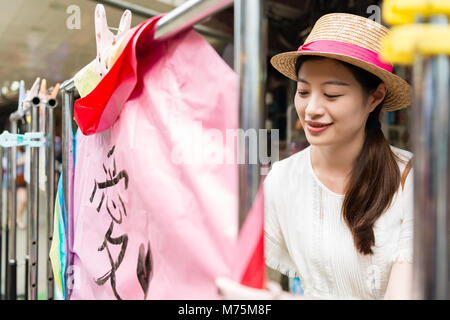 Frau schreiben Ihre Wünsche auf der sky Laterne, die Liebe in Chinesisch auf Shifen Alte Straße Abschnitt des Pingxi Bezirk geschrieben wird. Stockfoto