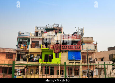 Hell gestrichenen Fassaden von side-by-side Gehäuse mit Wäsche trocknen auf dem Balkon. Am Straßenrand Wohnungen, Delhi, Indien. Stockfoto