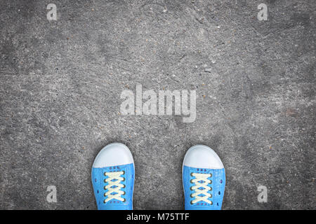 Jugendliche trägt blaue Schuhe stehen auf Betonboden Stockfoto