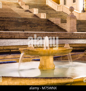 Die Fontana della Barcaccia (Brunnen der hässliche Boot) auf der Piazza di Spagna mit der Spanischen Treppe (Scalinata di Trinità dei Monti). Rom, Italien. Stockfoto