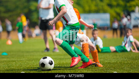 Junge Dribbling Fußball. Fußball-Spiel für Kinder. Training und Fußball Fußball School Turnier. Gruppe von Jungs spielen Fußball Match Stockfoto