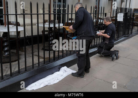 Zwei Arbeiter Farbe schwarz Eisengeländern an ein Restaurant in der Frith Street im Herzen von Soho, am 5. März 2018 in London, England. Stockfoto