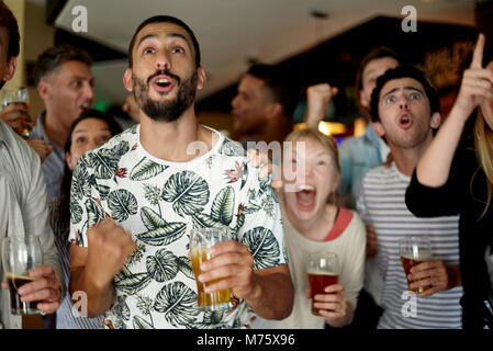 Sportbegeisterte aufgeregt beobachten Match in bar Stockfoto