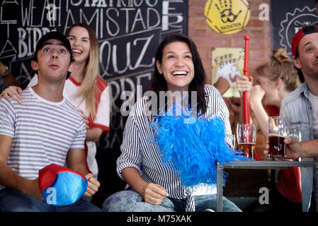 Sportbegeisterte beobachten Match in bar Stockfoto