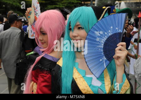 Schöne Thai Schwestern (eineiige Zwillinge) in Tracht & posing mit Lüftern an einem Japanischen Cosplay Festival in Bangkok, Thailand. Credit: Kraig Lieb Stockfoto