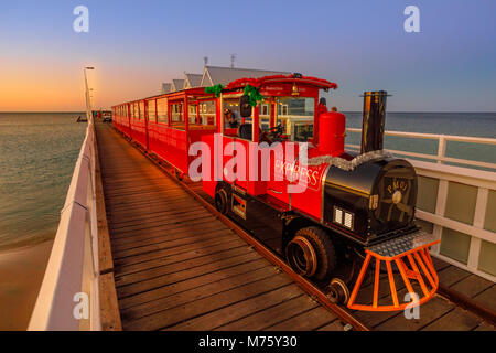 Busselton, Australien - 30 Dezember 2017: Busselton Jetty Zug auf der längsten hölzernen Pier Titel in der Welt erstreckt sich fast 2 km zum Meer. Malerische iconic in Western Australia in der Dämmerung Stockfoto