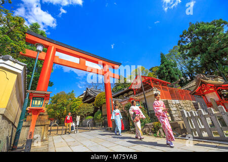 Kyoto, Japan - 24 April 2017: Japanische Frauen mit Kimono am Roten Torii Tor von Yasaka Schrein im Frühjahr Saison. Gion Schrein ist einer der berühmtesten Wallfahrtsorte zwischen Gion und Higashiyama Bezirk. Sonnigen Tag Stockfoto