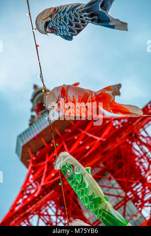 Tokyo, Japan - 23. April 2017: Nahaufnahme von Koinobori ein Karpfen-förmige wind Socken traditionell in Japan geflogen Tag der Kinder während der Goldenen Woche zu feiern. Verschwommen Tokyo Tower auf blauen Himmel. Vertikaler Dampfstoß Stockfoto