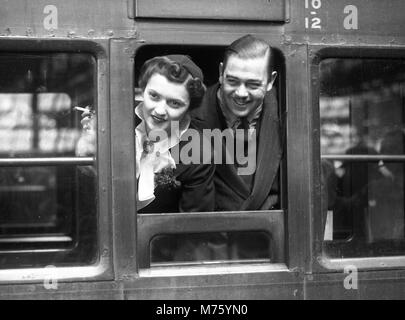 Flitterwochen-Paar, das mit dem Zug von Waterloo Station, London 1945, abreist Stockfoto