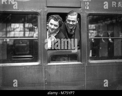 Flitterwochen-Paar, das mit dem Zug von Waterloo Station, London 1945, abreist Stockfoto