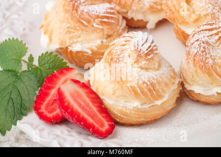 Windbeutel mit Sahne, Erdbeeren und Minze. Dessert für Gourmets. Selektiver Fokus Stockfoto