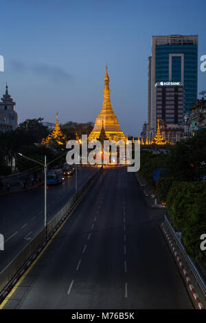 Sule Pagoda Road, beleuchtete Sule Pagode und Kolonialzeit und moderne Gebäude in der Innenstadt von Yangon (Rangun), Myanmar (Burma), im Morgengrauen. Stockfoto