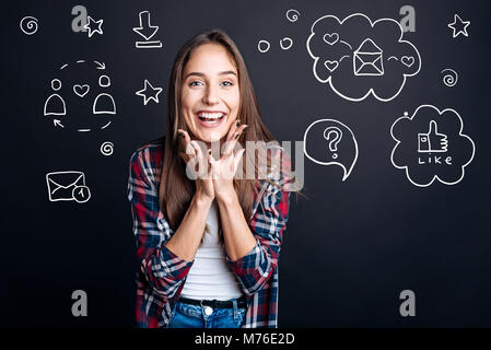 Glückliche Person lächelt, während sie ihr Profil im sozialen Netzwerk Stockfoto