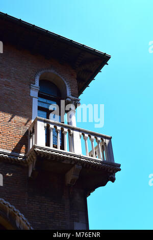 Ein Fenster auf dem Canal Grande Venedig Italien mit Balkon im tiefen Schatten gegen ein strahlend blauer Himmel. Stockfoto