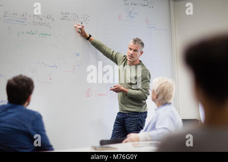 Lehrer mit White Board in der Erwachsenenbildung Kurs Stockfoto