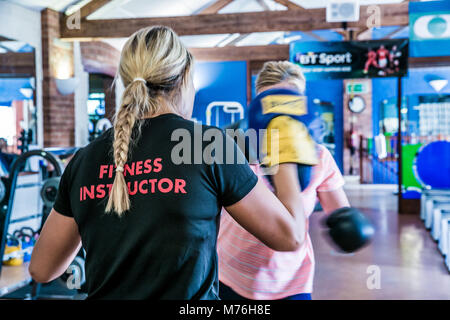 Weibliche Fitness Instructor Boxen mit weiblichen Kunden. In einer Eins-zu-eins Training im Fitnessraum Stockfoto