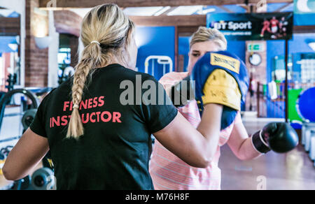 Weibliche Fitness Instructor Boxen mit weiblichen Kunden. In einer Eins-zu-eins Training im Fitnessraum Stockfoto