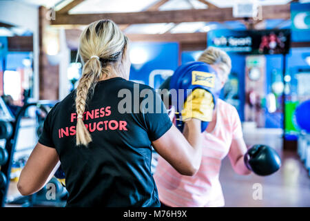 Weibliche Fitness Instructor Boxen mit weiblichen Kunden. In einer Eins-zu-eins Training im Fitnessraum Stockfoto