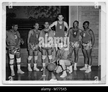 Ein historisches Foto eines Basketballteams, das die Athleten und ihre Mannschaftsuniformen in einem typischen Gruppenfoto aus dem frühen 20. Jahrhundert festhält. Stockfoto