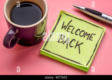 Willkommen zurück - Handschrift auf eine Haftnotiz mit einer Tasse Kaffee Stockfoto