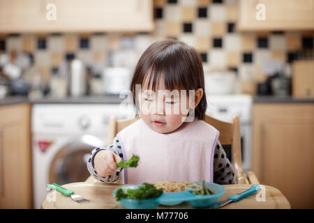 Baby girl unordentlich gegessen wird zu Hause Küche Stockfoto