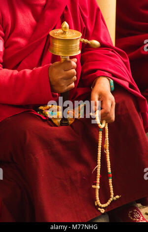 Tibetisch-buddhistischen Mönch mit gebetsmühle und Perlen im tibetischen Neujahr in der Dalai Lama Tempel, McLeod Ganj, Dharamsala, Himachal Pradesh, Indien Stockfoto