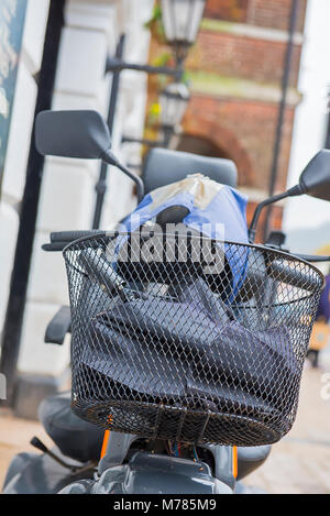 Wetter: Bridport, England, UK Freitag, den 9. März 2018. Ein Mobility Scooter mit einem Regenschirm und Regen Hut in den Korb ist auf Bridport High Street, während die Eigentümer Unterstände aus der Nieselregen in einem nahe gelegenen Cafe aufgegeben. Die trüben und nassen Bedingungen über das Wochenende fortsetzen, aber die Temperaturen viel wärmer als in letzter Zeit. Credit: PQ Images/Alamy leben Nachrichten Stockfoto