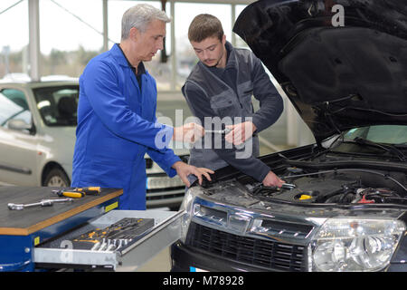 Student-Mechaniker von Lehrer im Automobil Berufsschule lernen Stockfoto