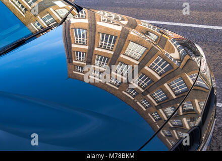 Motorhaube oder Haube und Fenster mit Gebäude reflektiert die Eigenschaft Entwicklung und Wohlstand Stockfoto